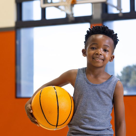 holding-basketball-smiling-boy-standing-in-school-2024-08-13-04-10-52-utc (1)560